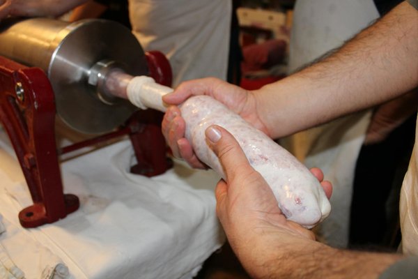How can tourists participate in detailed workshops on traditional British sausage making?